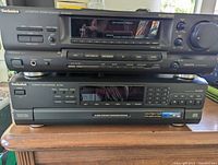 Front view of the stacked Technics AV Control Stereo Receiver SA-GX290 and Compact Disc Changer SL-PD8 on a wooden surface.