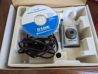 Two D-Link wireless internet cameras model DCS-G900 alongside a software CD and cables in molded packaging.