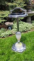 Front angle view of full ashtray unit on grass background