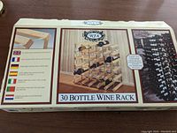 Top view of wine rack box showing label and packaging details with image of assembled rack and 30 bottle capacity indication.