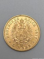 Full reverse of gold coin showing imperial eagle, date 1877 and denomination 5 Mark.