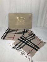 Scarf laid out with original Burberry presentation box embossed in gold logo visible