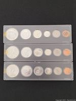 Three plastic strips each with six coins: $1, 50¢, 25¢, 10¢, 5¢, 1¢.