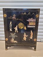 Front view showing double doors with painted chinoiserie scene of figures, pagoda and landscape