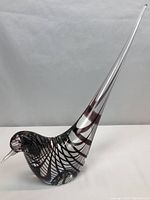 Full side view of purple swirl Murano glass bird on white background