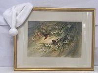 Full front view of framed watercolor painting with white hat prop