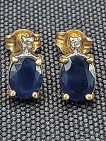 Front view of both earrings on black fabric