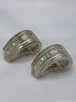 Pair of silver ear clips front three-quarter view