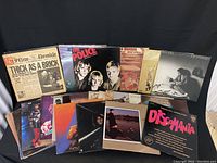 Photo showing arranged 13 vinyl record albums including titles and cover art for artists Jethro Tull, The Police, Billy Joel, Stevie Wonder and others.