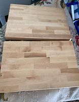 Top view of two large butcher block cutting boards showing parquet pattern of attached wood blocks.