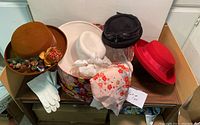 Lot arranged on a table, showing four wool hats, white gloves and organza scarf.