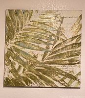 Front view of square canvas featuring metallic green palm frond leaves with scripted background.