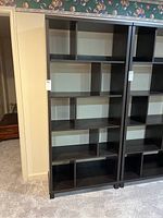 Front view of the dark brown display shelf showing multiple open compartments arranged asymmetrically