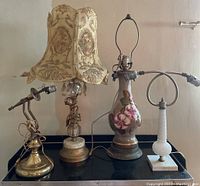 Four vintage electric lamp bases arranged in a row showing different styles and conditions