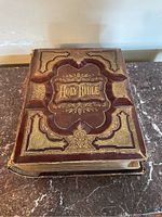 Front cover view showing embossed leather panels, gilt "Holy Bible" title and wear at edges