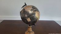 Full view of the vintage style globe on wooden base with visible map and black meridian.