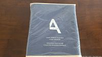 Photo of packaged closet organizer showing Avon logo and product name on front of bag.