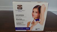 Front box image showing Silk'n Flash & Go Express hair removal device with woman using it on underarm. Highlights 300,000 pulses and permanent hair removal results.