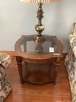Pair of matching solid wood end tables with glass inserts on top and lower shelves, showing detailed front and wood finish.