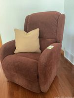 Front view of brown upholstered La-Z-Boy recliner with beige decorative pillow on seat.