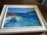 Full frontal view of framed painting laid flat on table