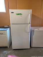 Front view of white Frigidaire top freezer refrigerator showing both doors closed.