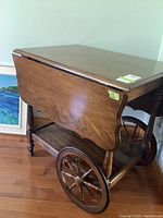 Side view showing one drop leaf down and oak finish