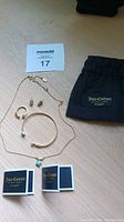 Overview of the Juicy Couture jewelry set including necklace, earrings, bracelet, ring, and pouch with original boxes.