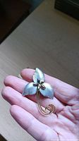 Front view of vintage sterling silver floral brooch held in hand showing design and finish