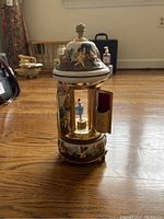 Front view of the music box showing the domed lid with cherub paintings and the open doors revealing the ballerina figure inside