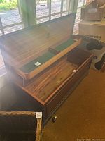 Open hope chest showing interior with hinged lid and green felt lined removable tray divided into sections.