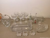 Photo showing the full assortment of crystal wine glasses, serving dishes, Princess House salt cellars, decorative bowl, vase, toothpick holder, and decorative bottle with stopper arranged on a table.