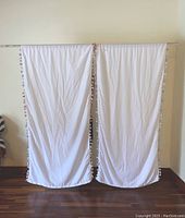 Two white fabric curtain panels hanging on a rod, measuring approximately 84x42 inches each, showing overall size and fit on rod.