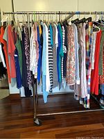 Wide view of rack with assorted medium sized women's clothes in various colors and patterns