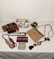 Overview of lot showing all items including purses, wallets, necklaces, bustle scarf, and belt.
