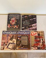 Five items displayed: two quilting books with colorful quilt covers, three magazines with titles Cross Quick and Quick & Easy shown front facing on a flat surface.