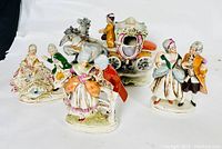 Overview of five antique Grafenthal porcelain figurines arranged in a row on a white background, showing various historical figures and a horse-drawn carriage.