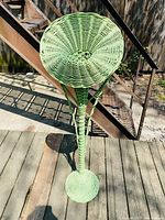 Front view of tall green wicker flower holder showing full height and woven basket top.
