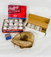 Full lot showing box of 12 Rawlings baseballs, vintage baseball cards box, catchers mitt, and deck of cards.