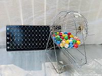 Complete BINGO set showing cage, balls, and black labelled number board.