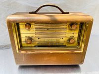 Front view of vintage RCA radio with control knobs and tuning dial showing brand and model details