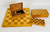 Overview showing wooden chessboard, chess piece box, backgammon box, and smaller checkerboard box.