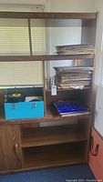 Wide view of wooden shelving holding box of 45 vinyl records and stacks of records