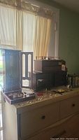 Three wooden jewelry boxes displayed together on dresser surface with assorted jewelry trays