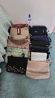 10 purses arranged together including Vera Bradley floral quilted purse and Nine West black crossbody