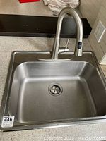 Top view of rectangular stainless steel sink with integrated drain. Shows Moen faucet with single lever and pull-out spray.
