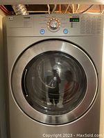 Front-facing view of LG front-load dryer installed in basement showing control panel and door