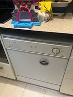 Closed view of the white Maytag MDB4100 dishwasher with front control panel including rotary dial and buttons.