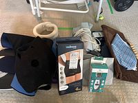 Lot showing all medical supplies included - support braces, thermometer, massager, and scale