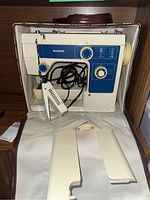 Front and top views of the Mason Model 515 sewing machine inside a carrying case, showing the foot pedal and cords.
